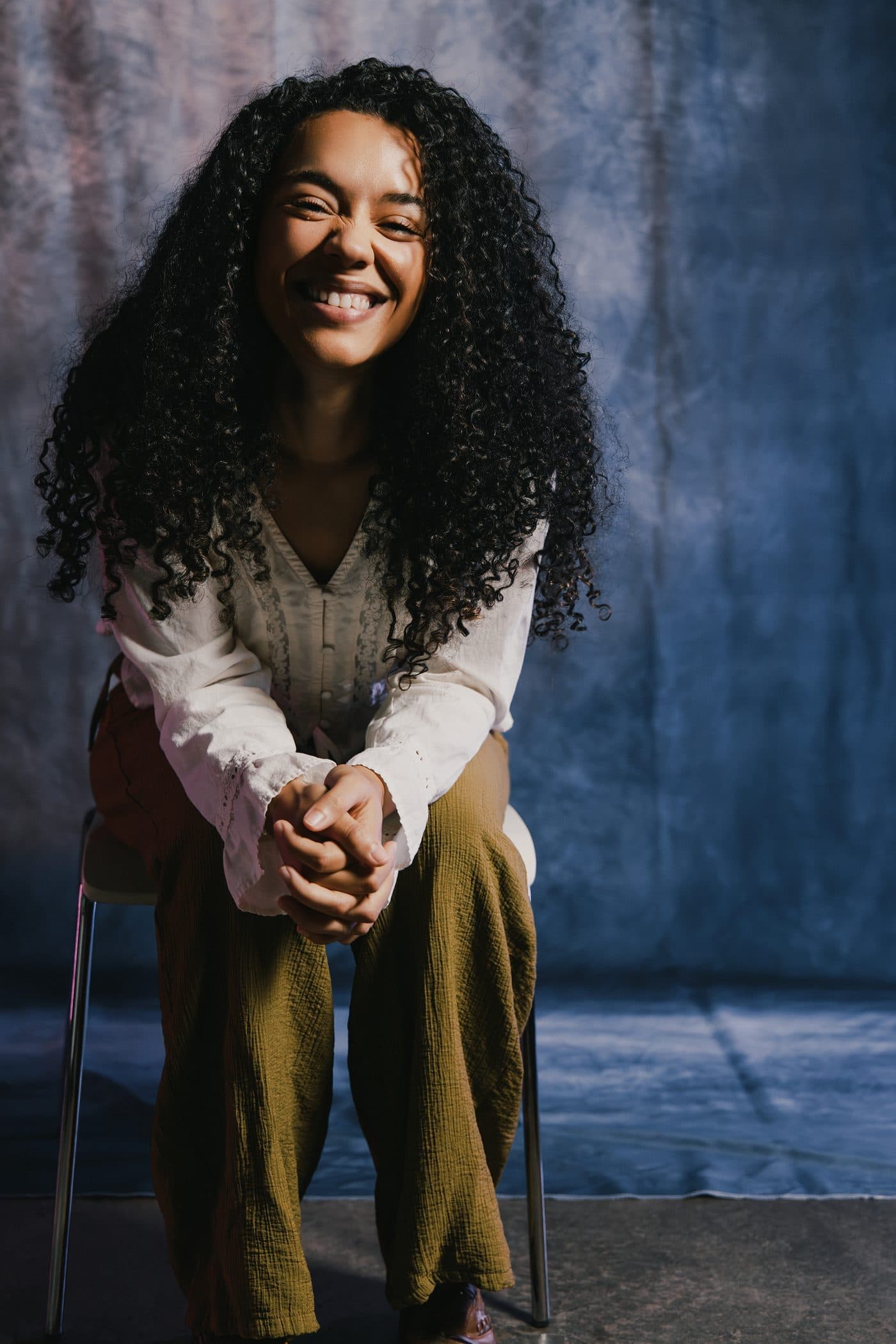 Emily Michael, smiling, seated on a stool